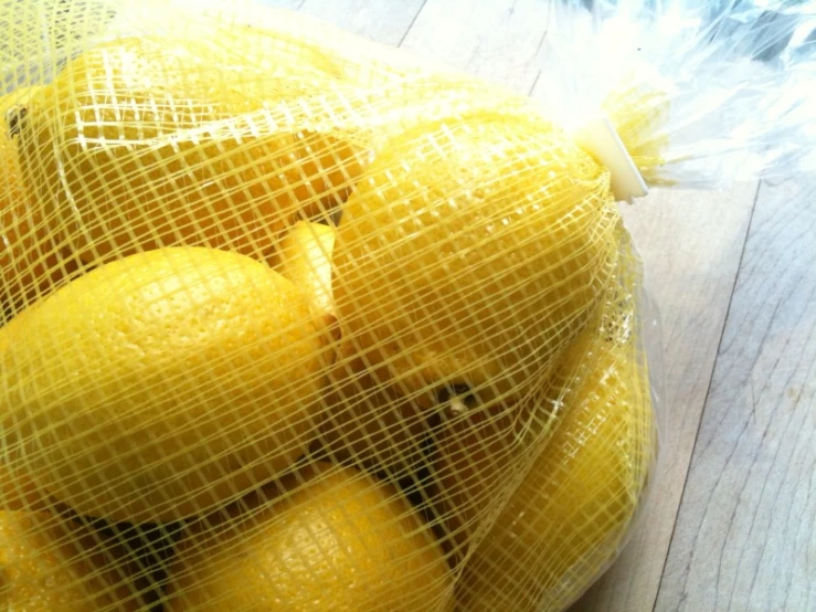 mesh bag full of lemons sitting on top of a table