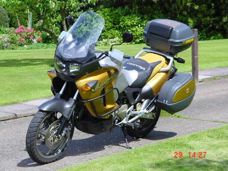 the motorcycle is parked on the sidewalk in the day time