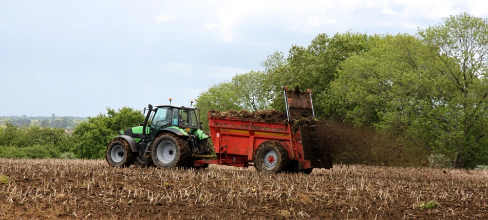 tractor and trailer being pulled by a farm machinery