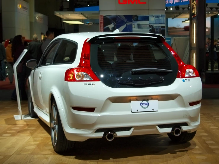 a small white car that is on display