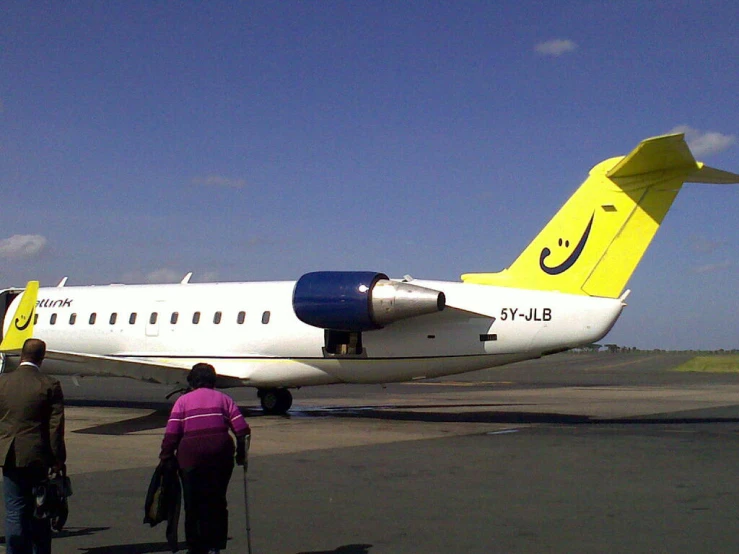a small white and yellow plane sitting on top of an airport tarmac