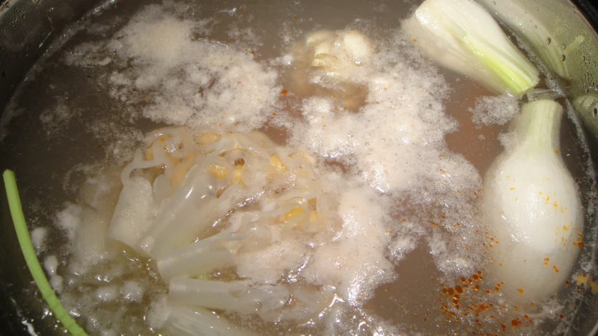 onions and garlic are boiling in a pot