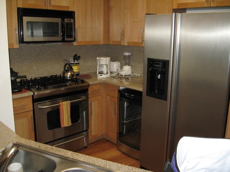 a kitchen with refrigerator, microwave, sink and stove