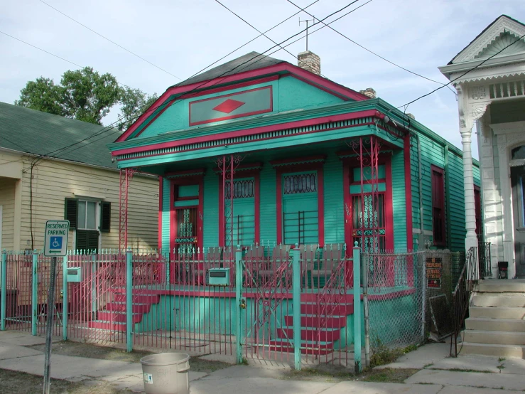 a small house with a green and red fence