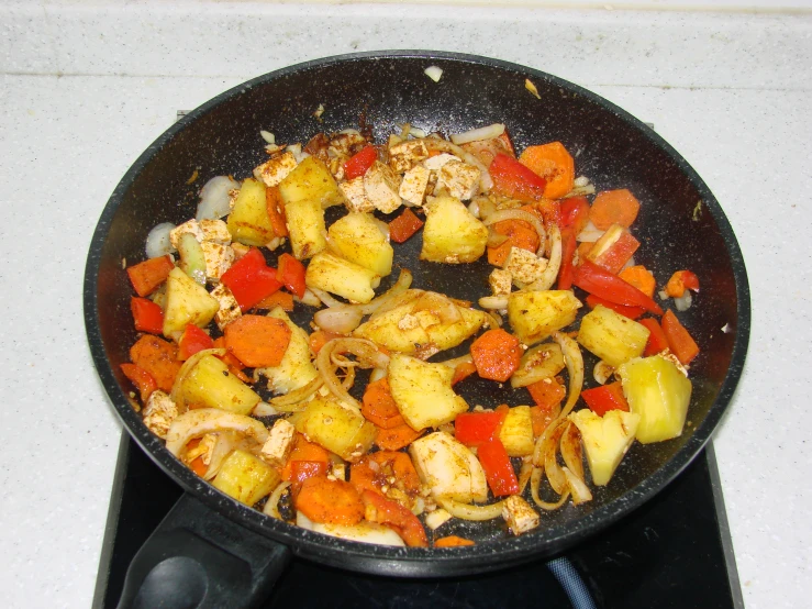 a pan with some vegetables cooking on the stove