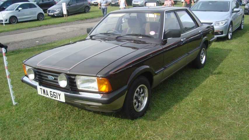 a brown car parked in a field of grass