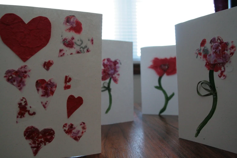 two cards with paper hearts and flowers made from flowers