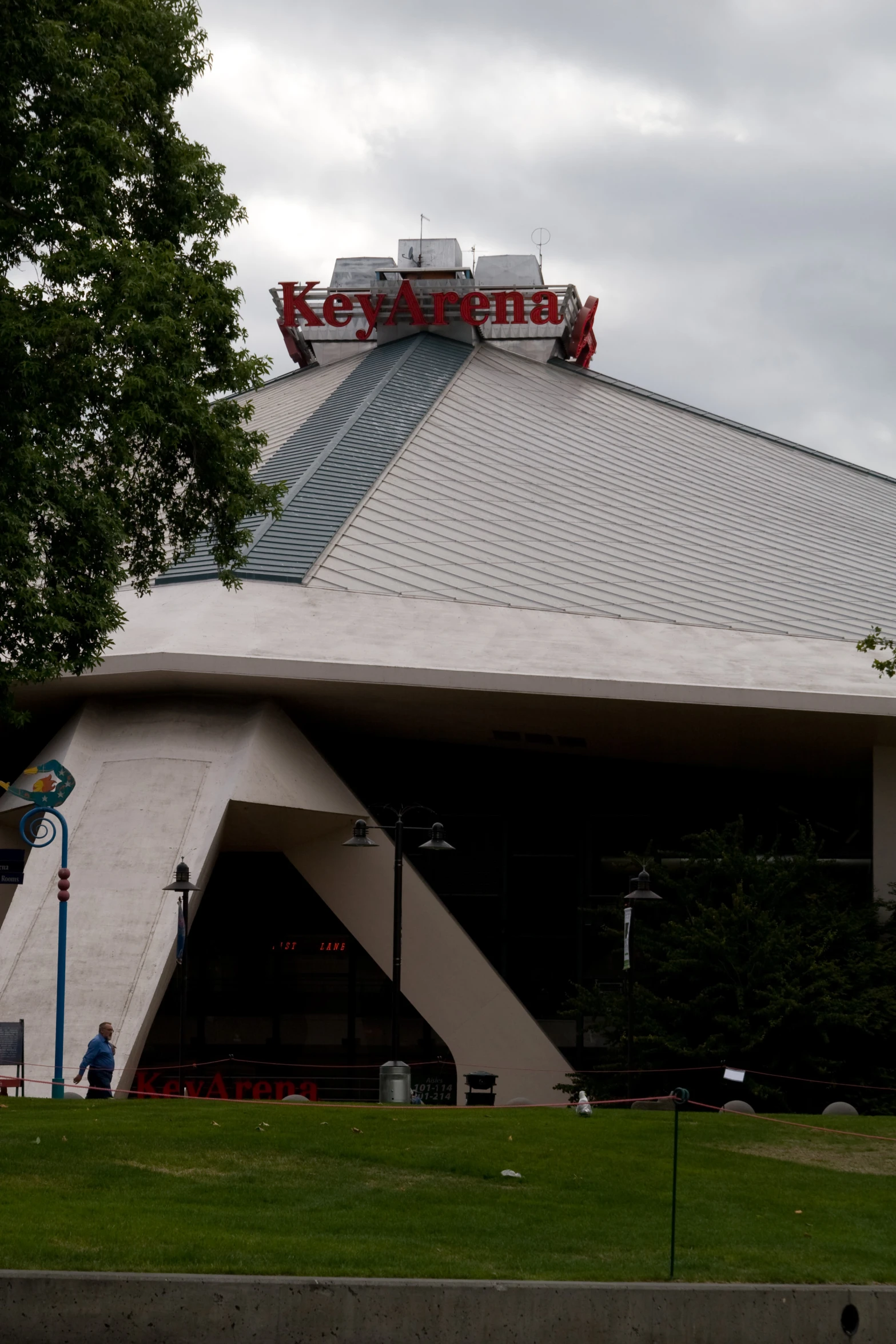 the exterior of a theater building with trees and grass