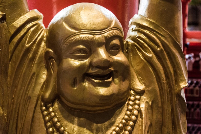 a statue that looks like a laughing person with his arms up