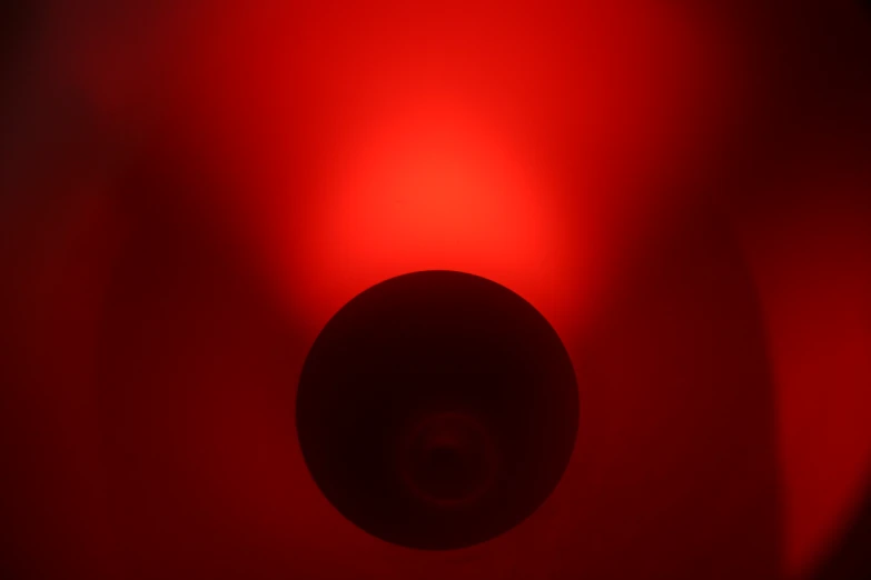 the back end of a round red object on a dark background