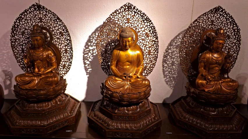 a collection of gold buddha statues and carvings