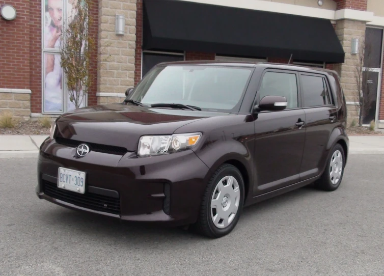 a black toyota car is shown in front of a building