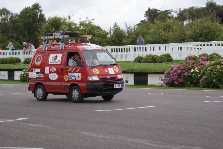 a red van with the door open and luggage strapped on the back