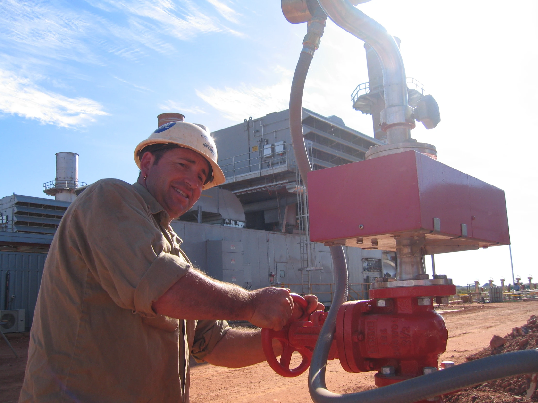 a man in a hardhat holding onto two fire hydrants