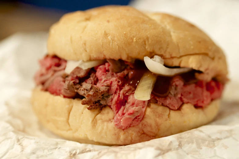 a meat sandwich is sitting on wax paper