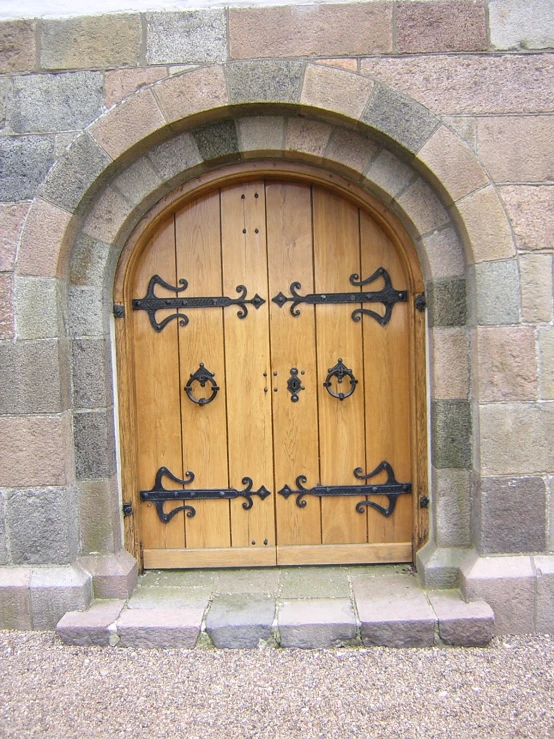 a door in a wall with iron handles and door handles