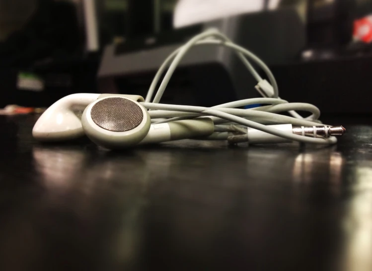 two white ear buds laying on top of a table