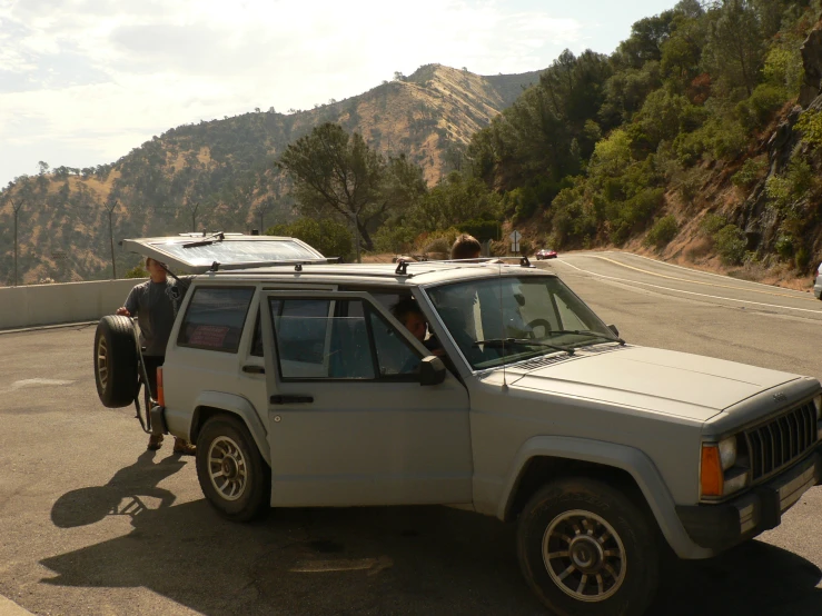 there is a jeep with a surfboard on the roof