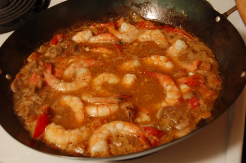the shrimp is being cooked in the large pan