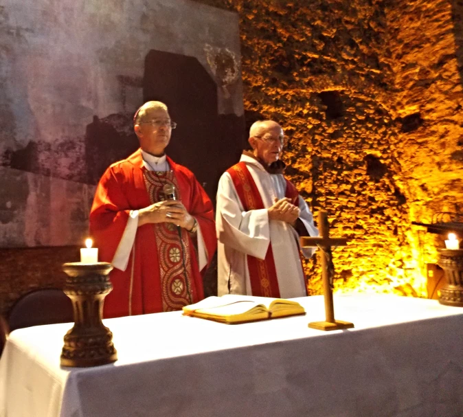 two people in white robes standing at a table