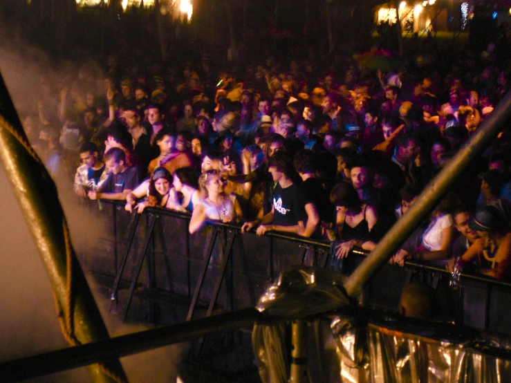 a crowd of people standing around a metal railing