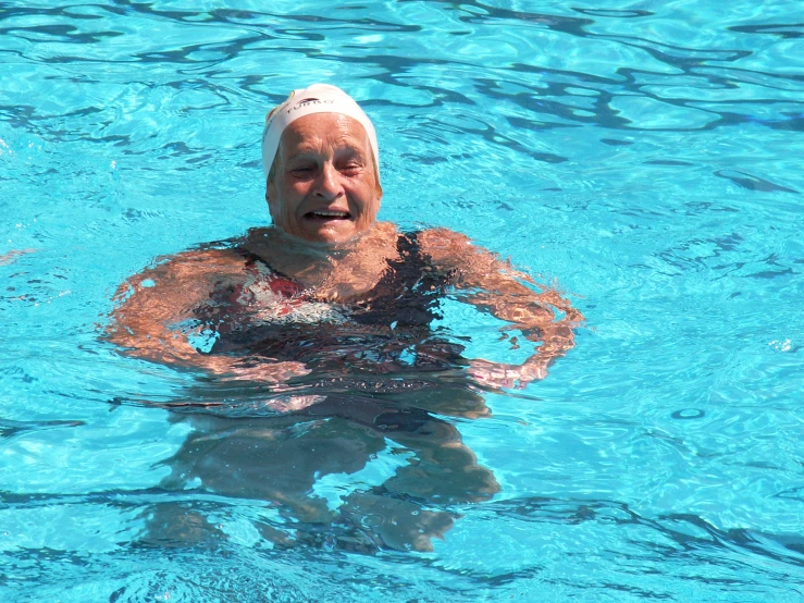 an elderly man swimming in a pool with 