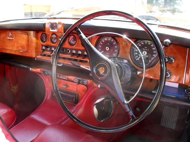 a dashboard view of an old car with wood paneling