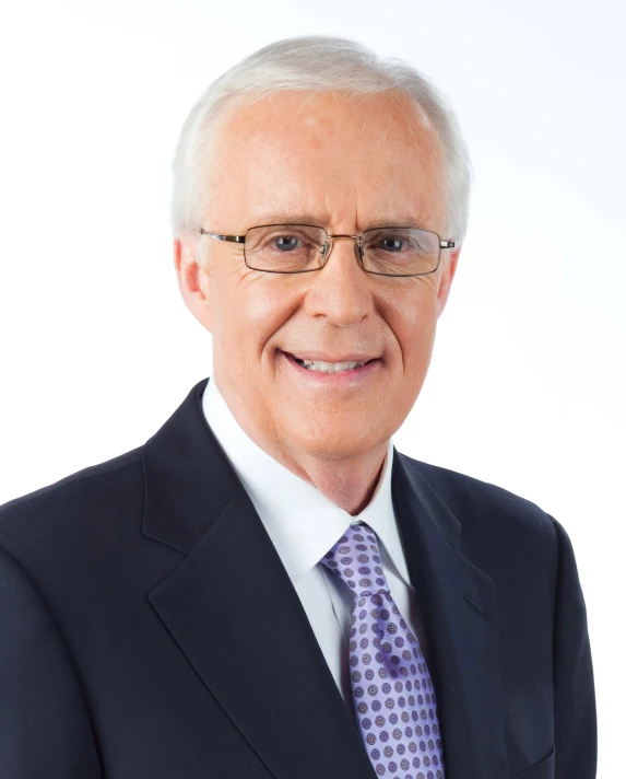 a man in a suit and tie smiling for a portrait