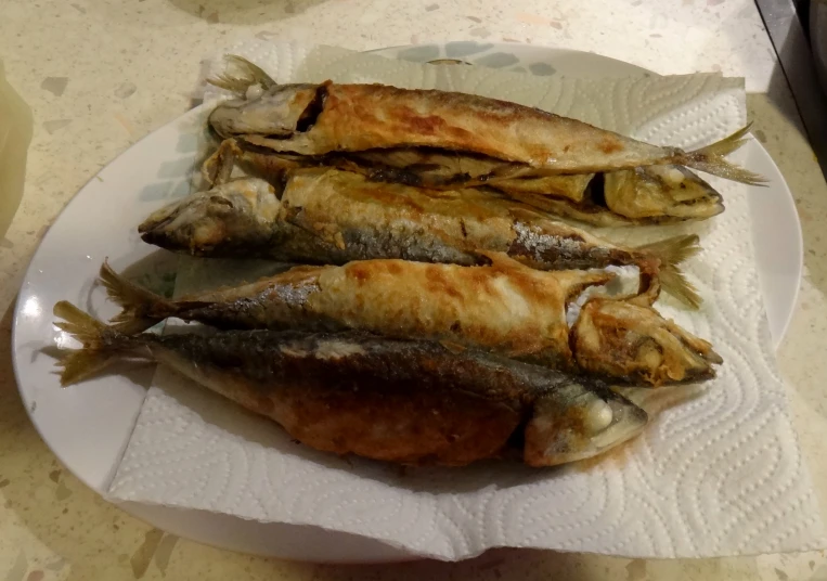 two fish are on a plate, one of which is partially eaten