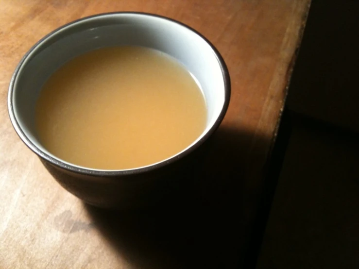 a white cup filled with liquid on top of a table