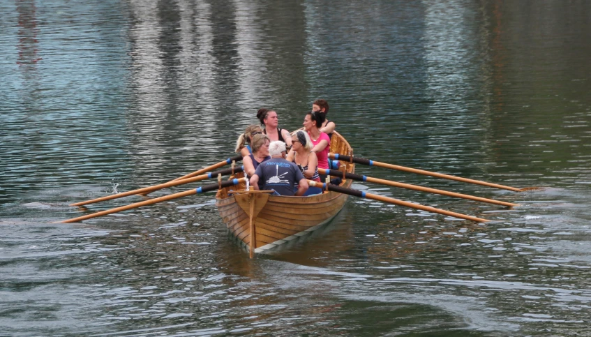 the four people are rowing in the small boat