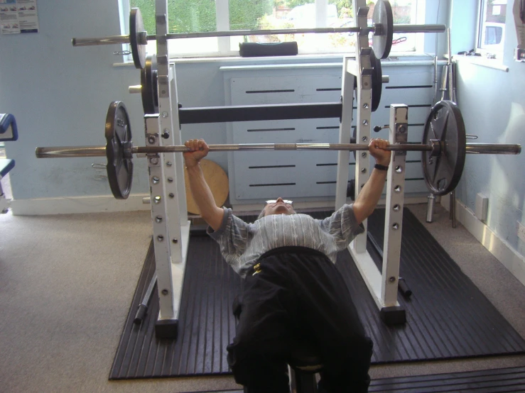 a man working on squats with a pair of barbells