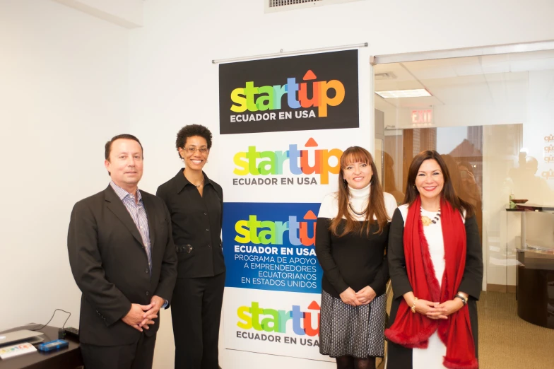 three people standing next to a start up sign