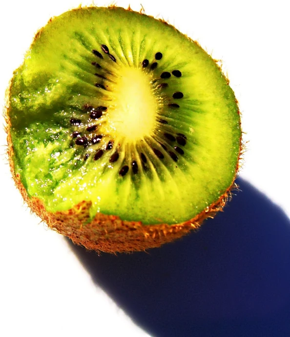 an green kiwi sitting on top of a white surface