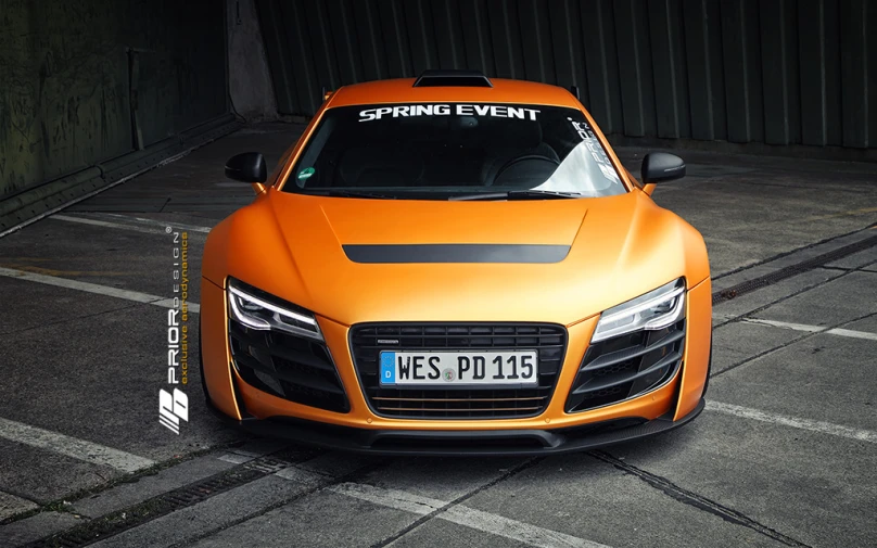 an orange sports car parked on the side of the street