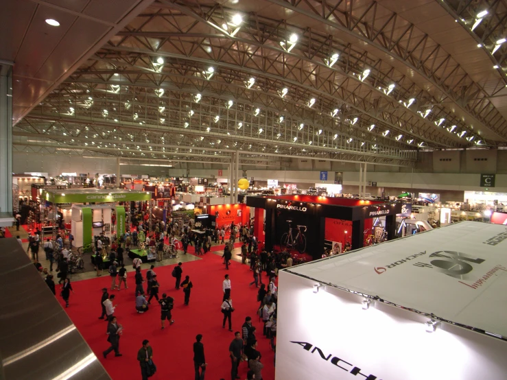 people walking around in a crowded building and various booths