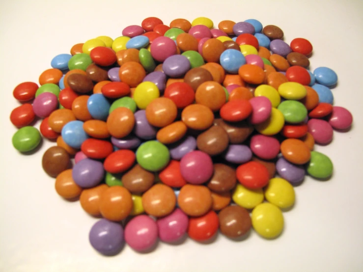 candy pebbles on a white surface, many colors