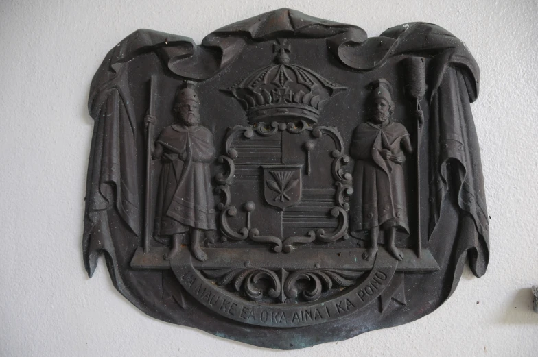 a coat of arms with three people standing next to it