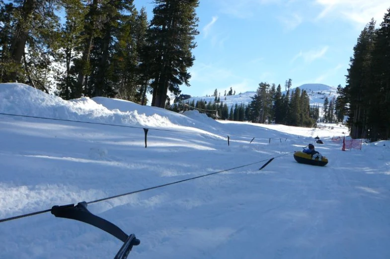 a sled pulled by a man on a mountain slope