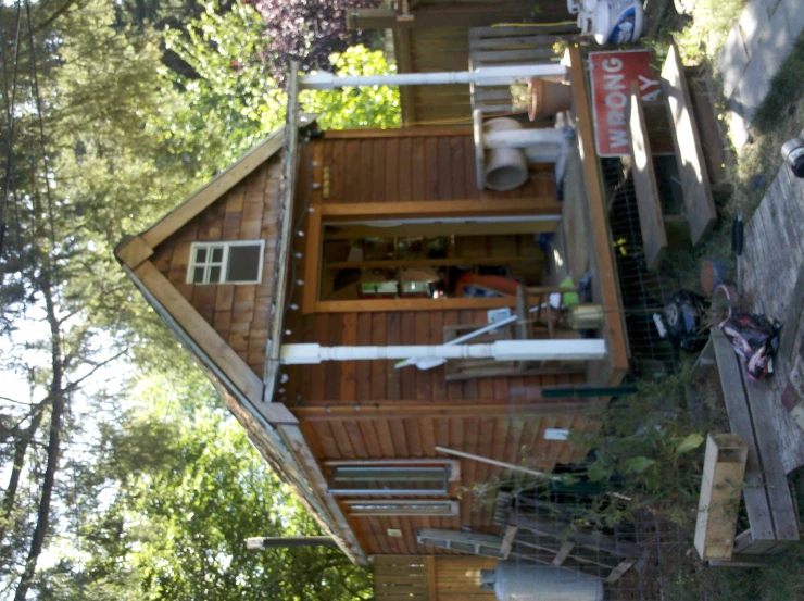 a tiny wood house on the ground with a ramp