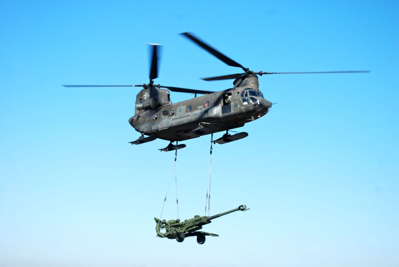 two military aircraft are in the air while one plane hangs from a rope