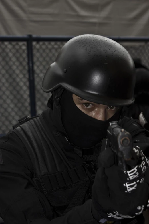 a man wearing a black outfit and holding a gun