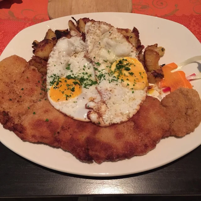 plate of fried chicken and eggs on wooden surface