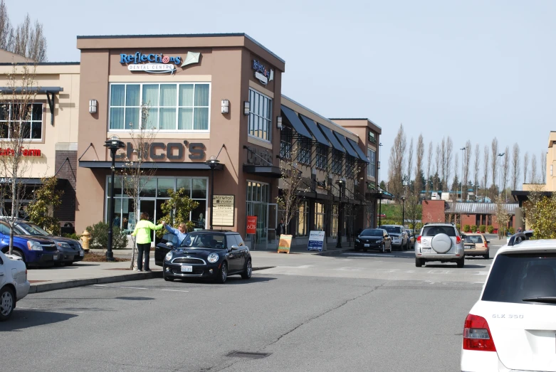 cars line the street as people are stopped at a crosswalk