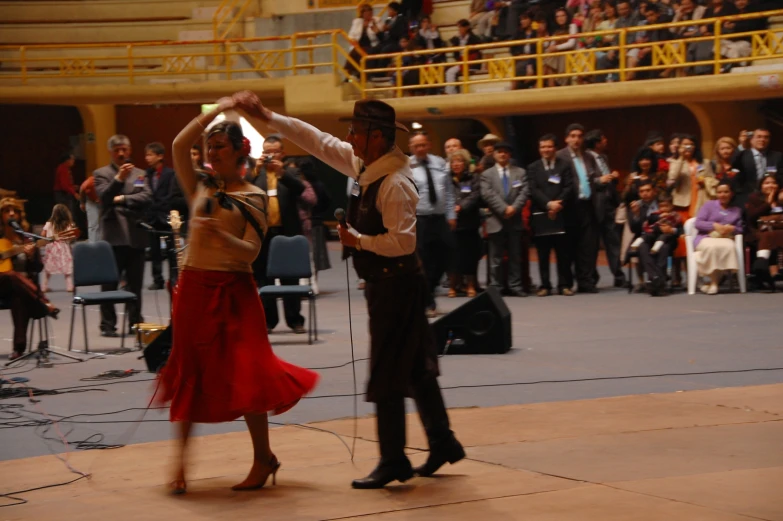 two people dancing in front of a large crowd