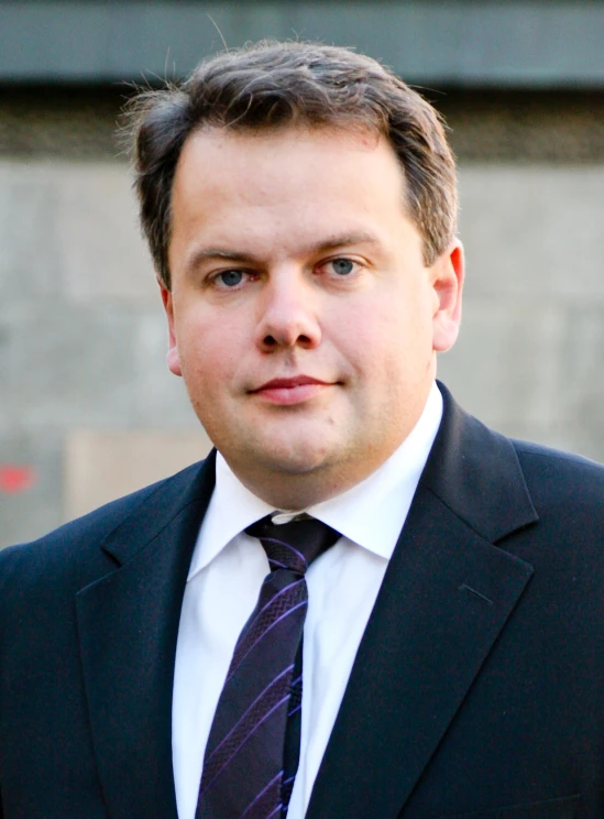 a close up of a man wearing a suit and tie