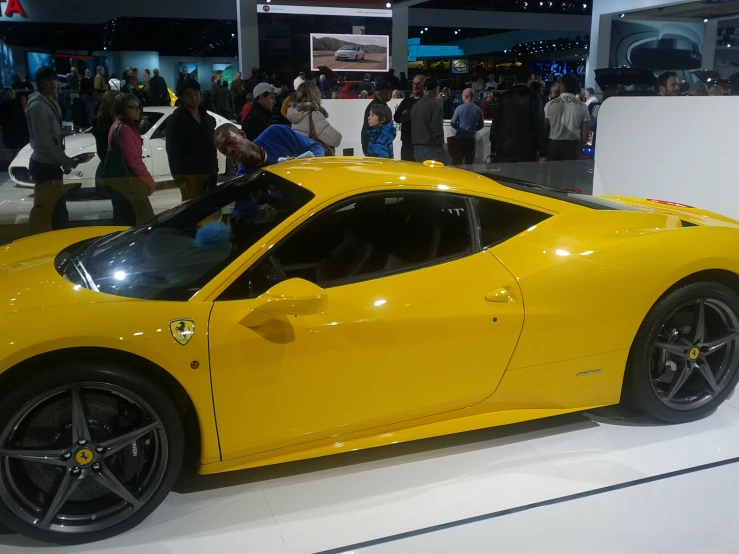 there is a yellow sports car on display at a show