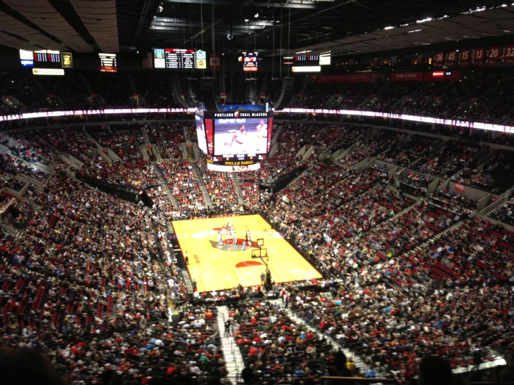 large crowds in the bleachers at an indoor basketball game