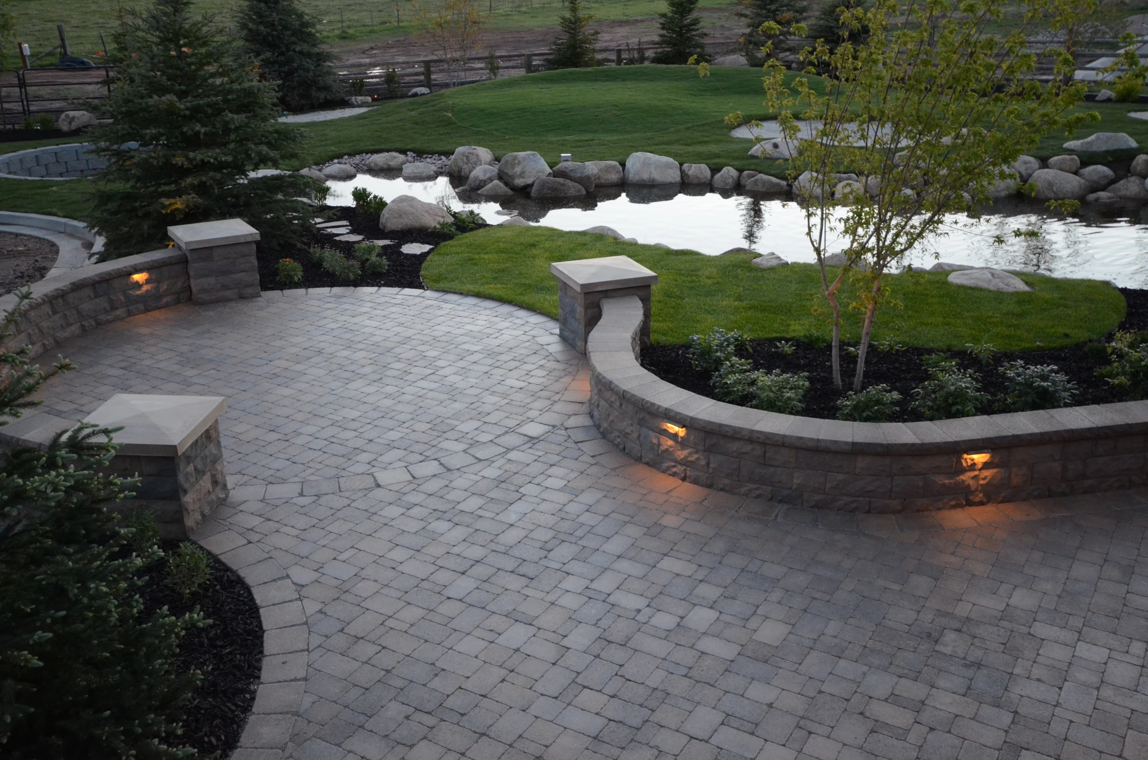 an outside view of a stone paved patio with lighting