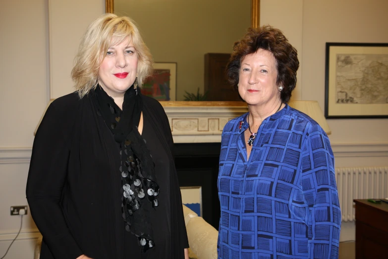 two women standing next to each other in a room